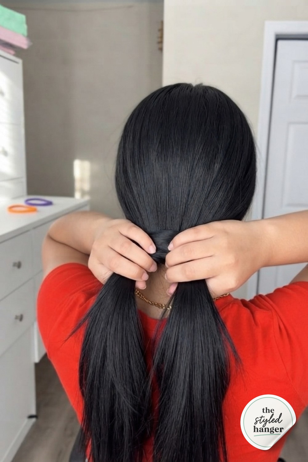 Gathering hair into a low ponytail as the first move in the easy hair tie ponytail hack